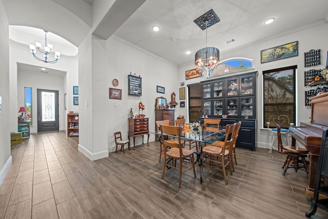 dining room with ornamental molding, hardwood / wood-style flooring, and an inviting chandelier