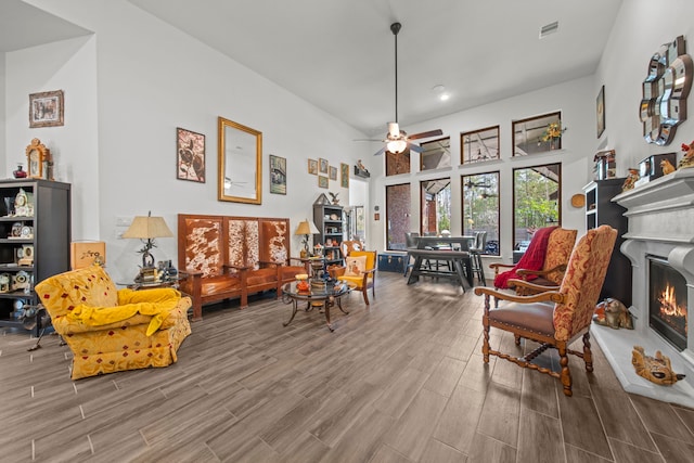 interior space featuring a towering ceiling, ceiling fan, and wood-type flooring