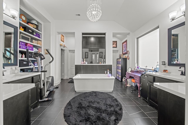 bathroom with vaulted ceiling, a washtub, vanity, a notable chandelier, and tile patterned flooring