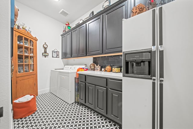 clothes washing area featuring independent washer and dryer and cabinets