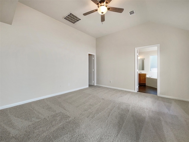 empty room featuring ceiling fan, lofted ceiling, and dark colored carpet