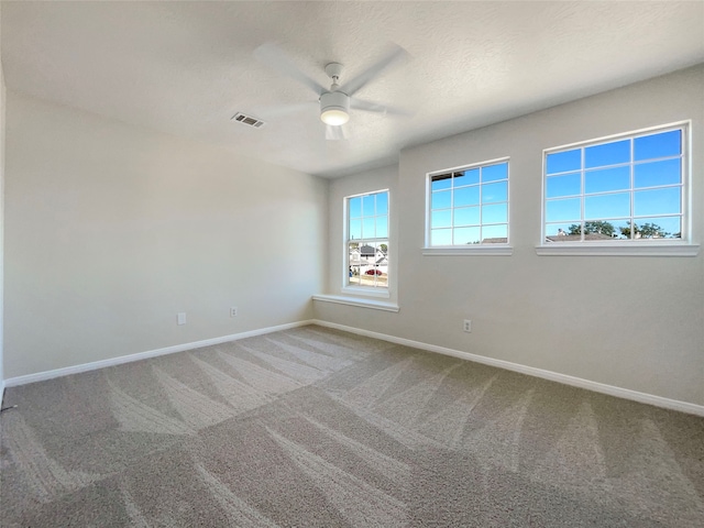 empty room featuring ceiling fan, a textured ceiling, and carpet floors