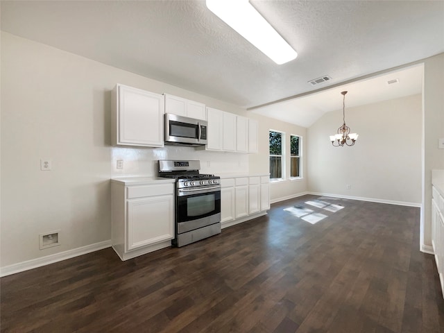 kitchen with dark hardwood / wood-style flooring, appliances with stainless steel finishes, vaulted ceiling, and white cabinets