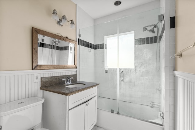 full bathroom featuring vanity, combined bath / shower with glass door, and toilet