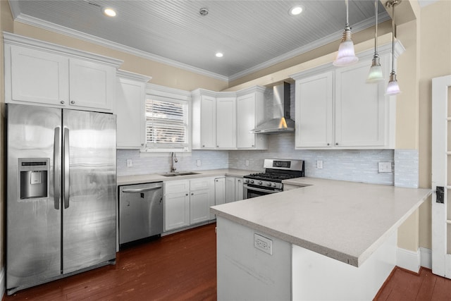 kitchen featuring wall chimney exhaust hood, kitchen peninsula, white cabinetry, appliances with stainless steel finishes, and dark hardwood / wood-style flooring