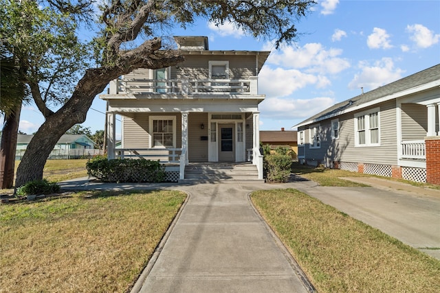 front of property with a front yard, covered porch, and a balcony