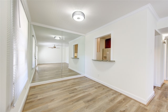 hall with ornamental molding and light wood-type flooring