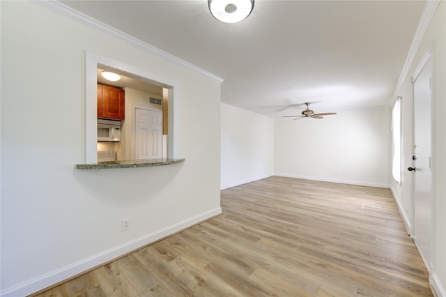 interior space with light hardwood / wood-style floors, crown molding, and ceiling fan