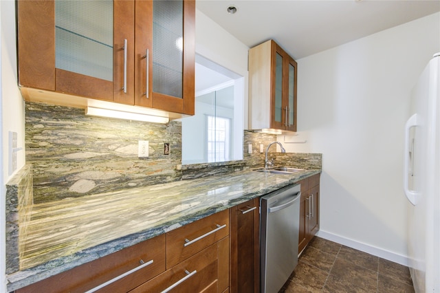 kitchen with light stone countertops, sink, stainless steel dishwasher, white fridge, and decorative backsplash