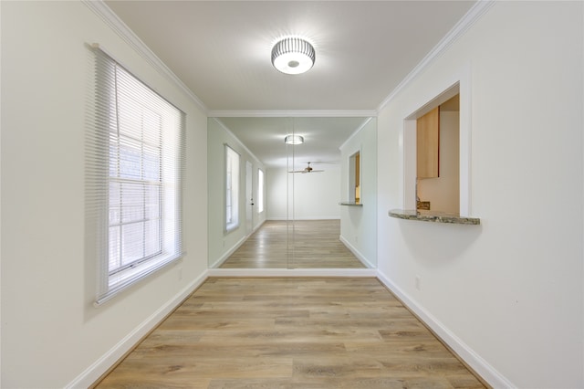 corridor featuring ornamental molding and light hardwood / wood-style flooring