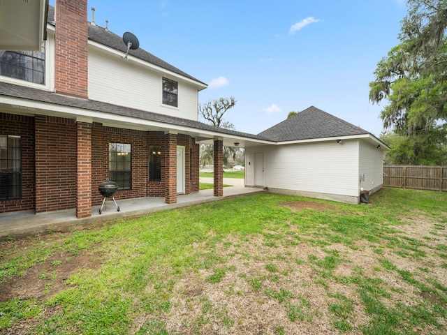 back of property featuring a patio and a yard