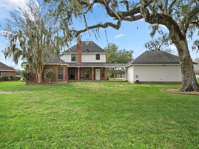 rear view of property with a yard and a patio