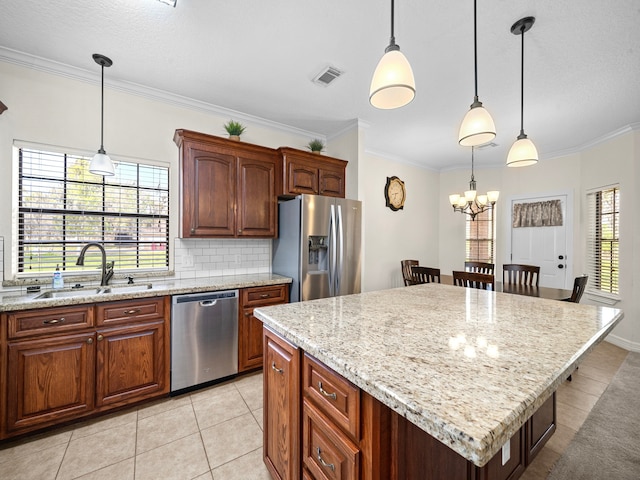 kitchen featuring a center island, appliances with stainless steel finishes, sink, and decorative light fixtures