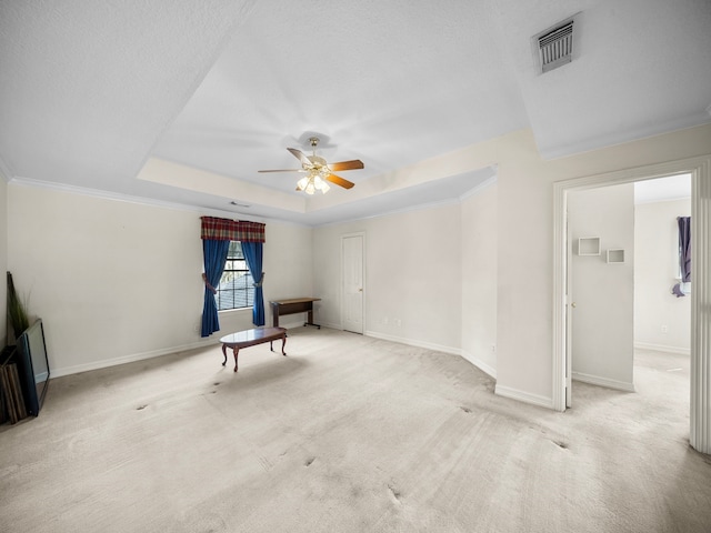 carpeted spare room with crown molding, a raised ceiling, a textured ceiling, and ceiling fan