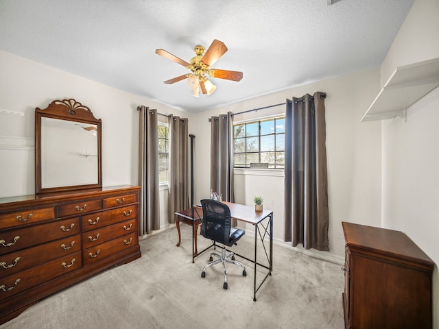 office space with light carpet, a textured ceiling, and ceiling fan