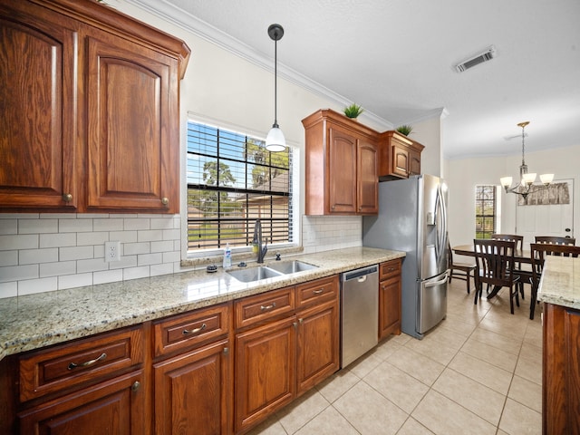 kitchen with ornamental molding, stainless steel appliances, sink, and pendant lighting