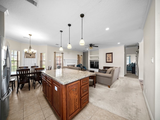 kitchen featuring light carpet, a center island, stainless steel fridge with ice dispenser, pendant lighting, and ceiling fan with notable chandelier