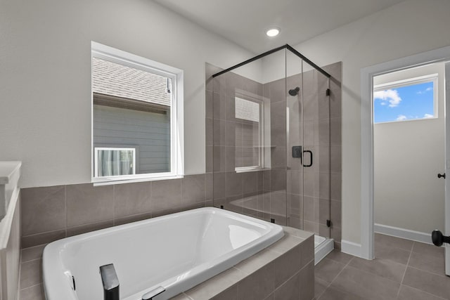 full bath with baseboards, tiled tub, recessed lighting, a stall shower, and tile patterned floors