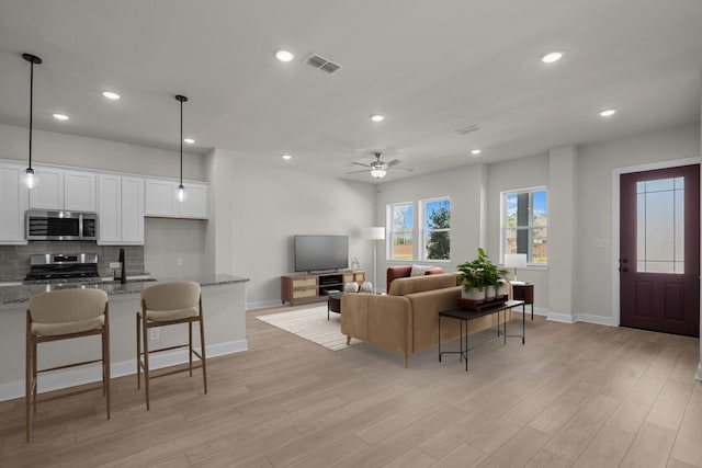 living area featuring recessed lighting, visible vents, and light wood-style floors