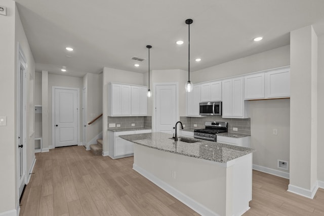 kitchen with visible vents, light wood-type flooring, a sink, appliances with stainless steel finishes, and white cabinets