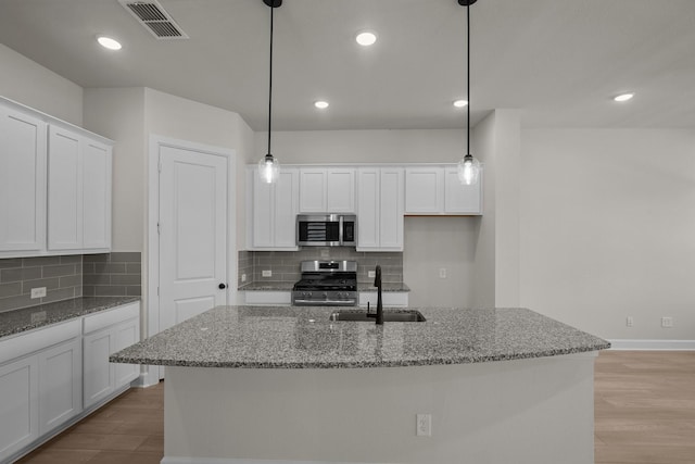 kitchen with visible vents, light wood-type flooring, a sink, white cabinetry, and appliances with stainless steel finishes