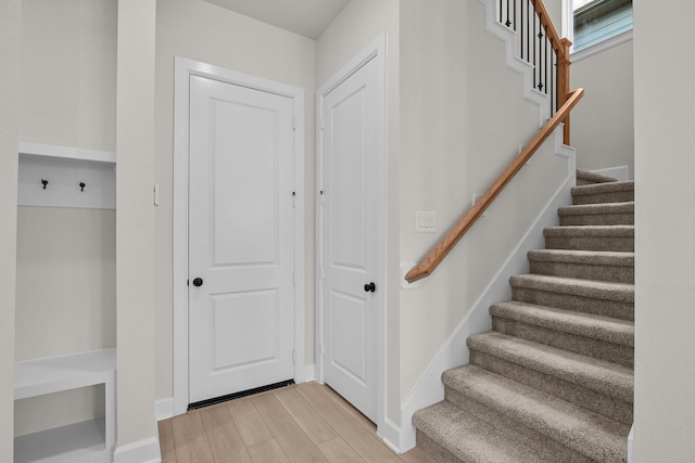 staircase featuring baseboards and wood finished floors