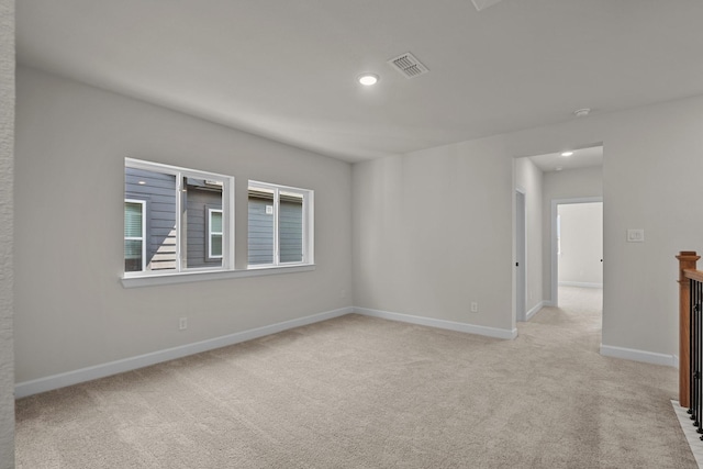 empty room with recessed lighting, visible vents, light colored carpet, and baseboards