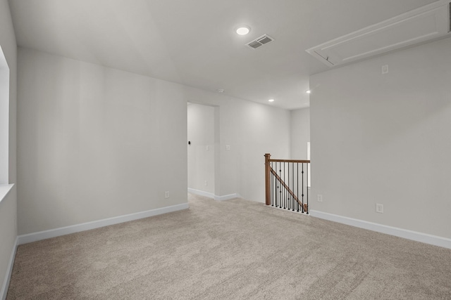 empty room with visible vents, baseboards, carpet, attic access, and recessed lighting