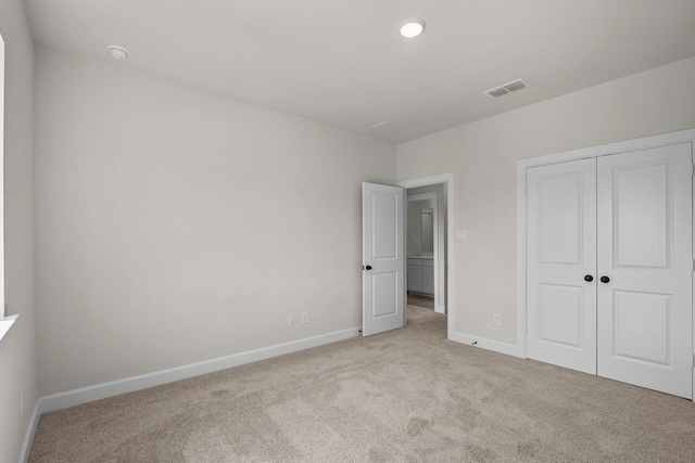 unfurnished bedroom featuring baseboards, visible vents, carpet floors, and a closet