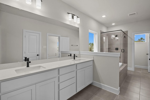 bathroom featuring tile patterned flooring, visible vents, a shower stall, double vanity, and a sink