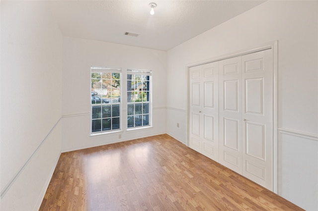 unfurnished bedroom featuring a closet and light wood-type flooring