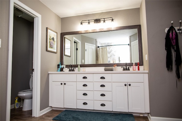 bathroom featuring vanity, curtained shower, wood-type flooring, and toilet