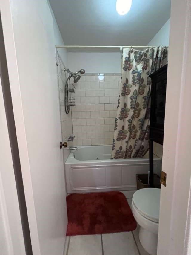 bathroom with toilet, tile patterned floors, and shower / bath combo with shower curtain