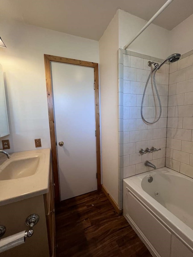 bathroom with vanity, tiled shower / bath combo, and hardwood / wood-style flooring