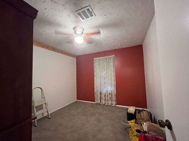 spare room featuring ceiling fan, a textured ceiling, and carpet floors