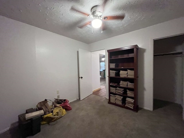 miscellaneous room with a textured ceiling, carpet floors, and ceiling fan