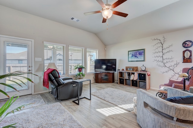 living room with a wealth of natural light, vaulted ceiling, light hardwood / wood-style flooring, and ceiling fan