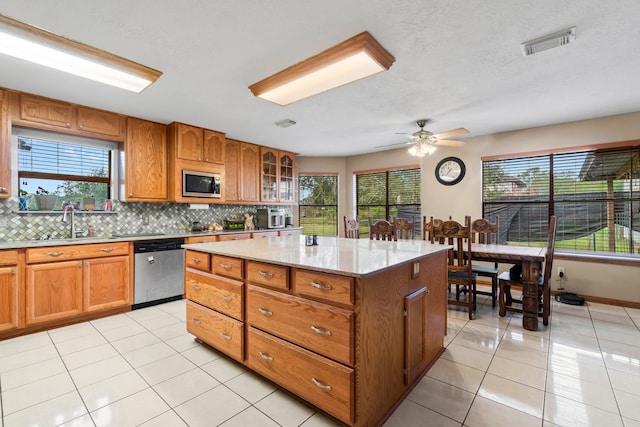 kitchen featuring a center island, appliances with stainless steel finishes, light tile patterned floors, and plenty of natural light