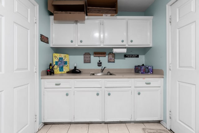 kitchen with sink, white cabinetry, and light tile patterned flooring