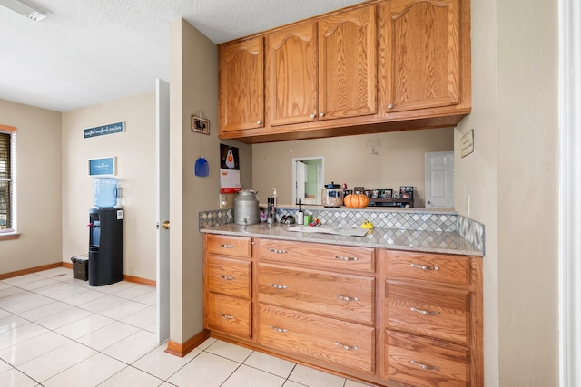 kitchen with a textured ceiling and light tile patterned flooring