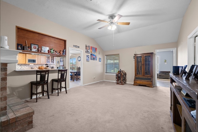 carpeted living room featuring lofted ceiling, a textured ceiling, and ceiling fan