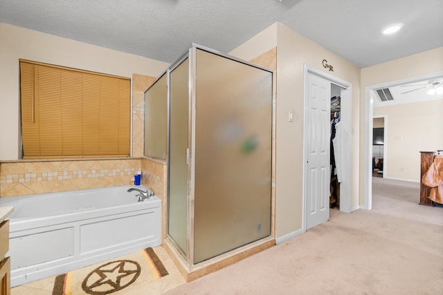 bathroom with a textured ceiling, plus walk in shower, and ceiling fan