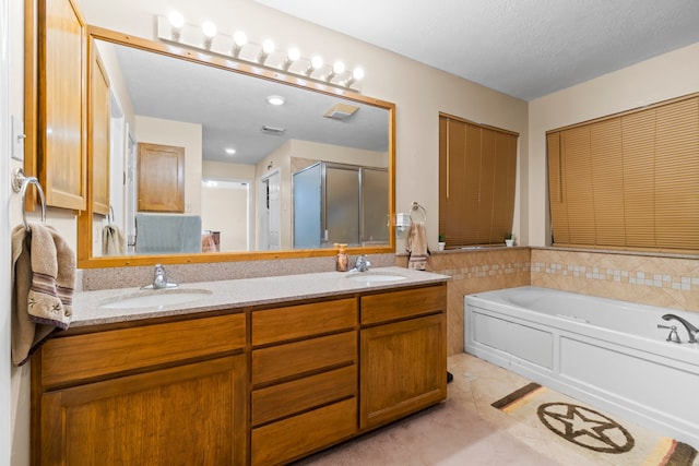 bathroom with vanity, a textured ceiling, plus walk in shower, and tile patterned flooring