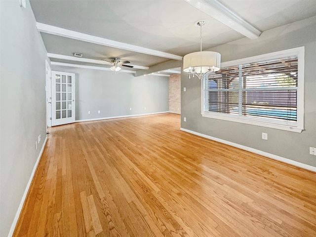 interior space with light hardwood / wood-style floors, beamed ceiling, and ceiling fan with notable chandelier