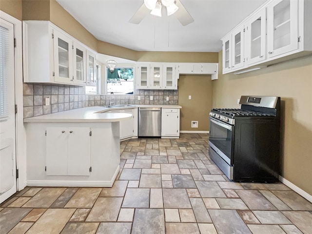 kitchen featuring decorative backsplash, stainless steel appliances, sink, white cabinets, and ceiling fan