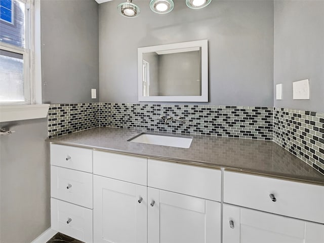 bathroom featuring vanity and tasteful backsplash