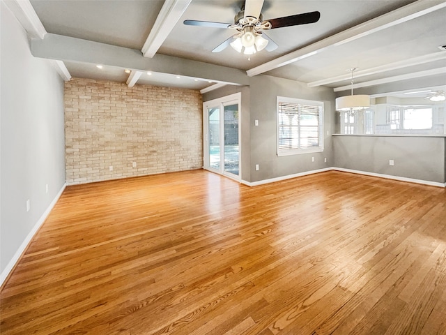 unfurnished room with ceiling fan, brick wall, beamed ceiling, and light wood-type flooring