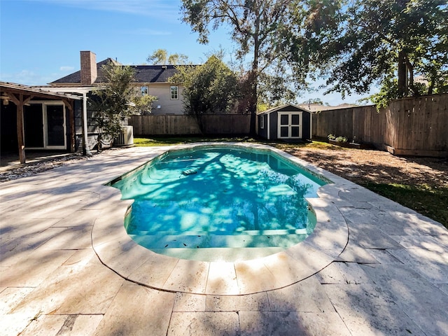 view of swimming pool featuring a storage shed and a patio area