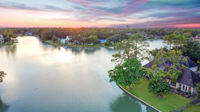 aerial view at dusk featuring a water view