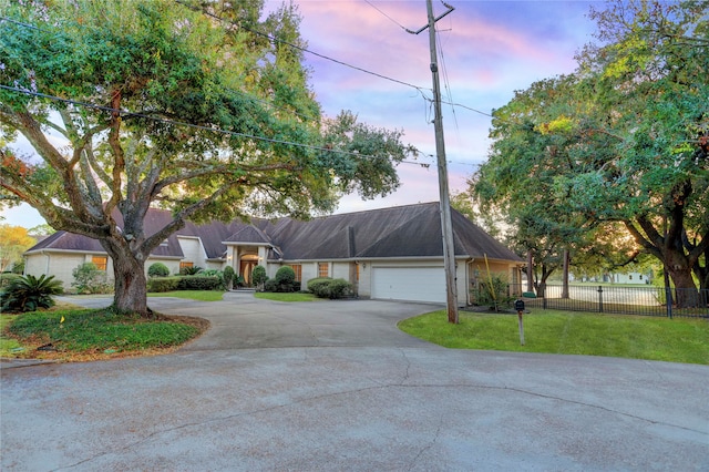 single story home with a garage and a lawn